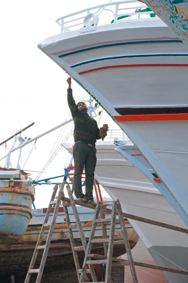 محمد مورو يرسم على واجهة أحد المراكب